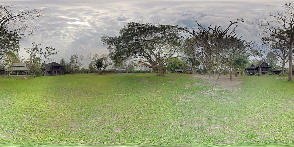Panoramic view of the museum grounds with mature trees and traditional houses scattered across green lawns